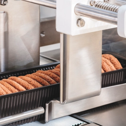 Sistema robotizado para dosificación y colocación precisa de productos frágiles como galletas o snacks.