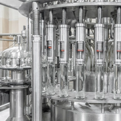 Cabezal doble llenando envases marrones en producción cosmética
