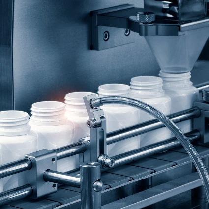 Cabezal dosificador llenando frascos plásticos para productos cosméticos líquidos o gelificados